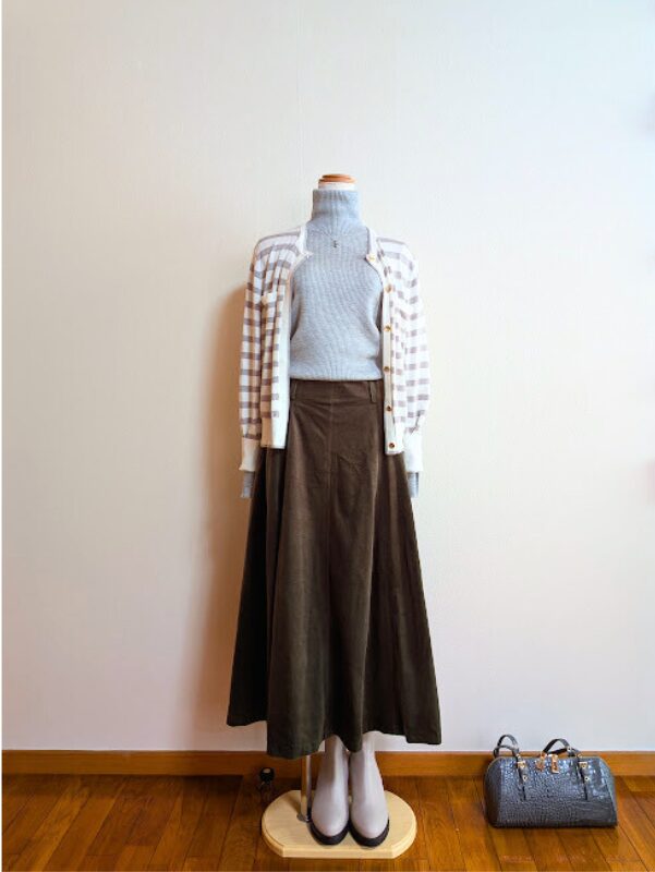 ライトグレータートルニットにダークグリーンフレアスカート、グレーボーダーカーディガンを合わせたコーデ