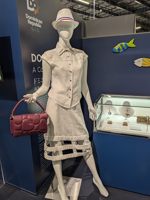 大阪万博のトルソー（ホワイトブラウスにホワイトスカート、ホワイトキャップ、ダークピンクのバッグ）