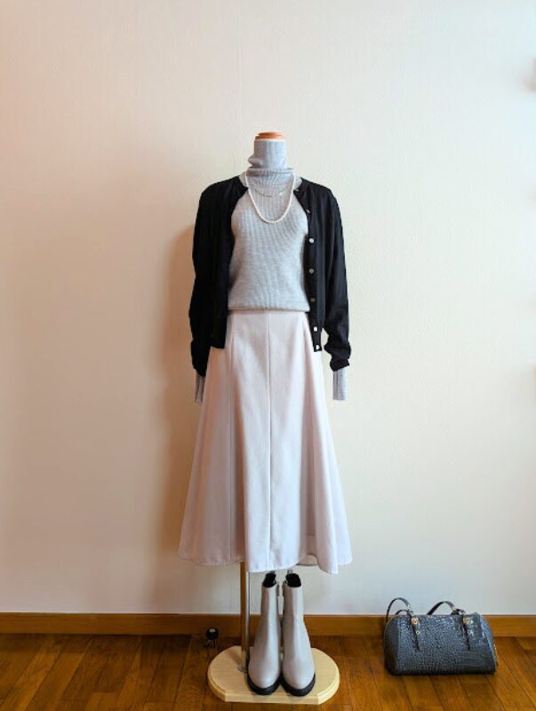 ライトグレータートルニットにホワイトフレアスカート、ブラックカーディガンを合わせたコーデ