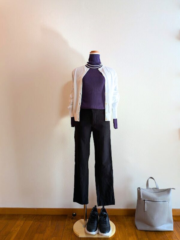 パープルタートルニットにブラックストレートパンツ、ホワイトカーディガンを合わせたコーデ