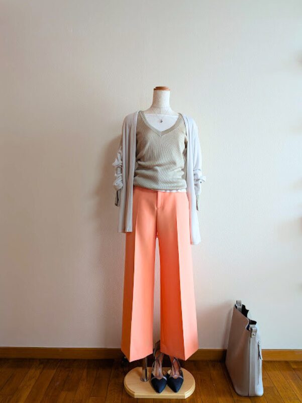 40代・50代コーデ ホワイトキャミソールにライトグレーニットを重ね、ライトベージュのカーディガン、オレンジワイドパンツを合わせたトルソーコーデ