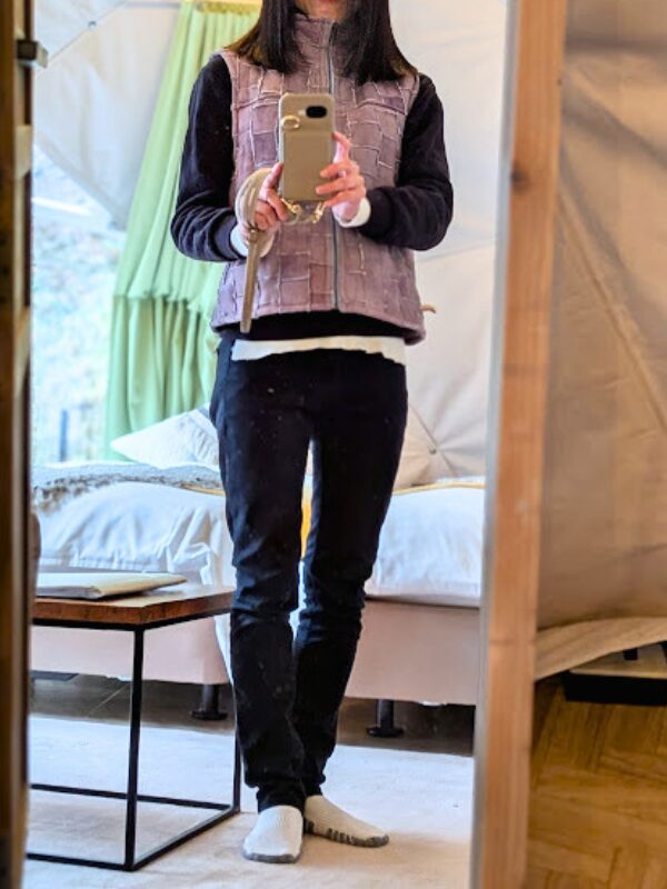 ホワイトカットソーにブラックパーカーを重ね、ラムレザーベストとブラックスリムパンツを合わせたコーデ(私自身のグランピングコーデ)