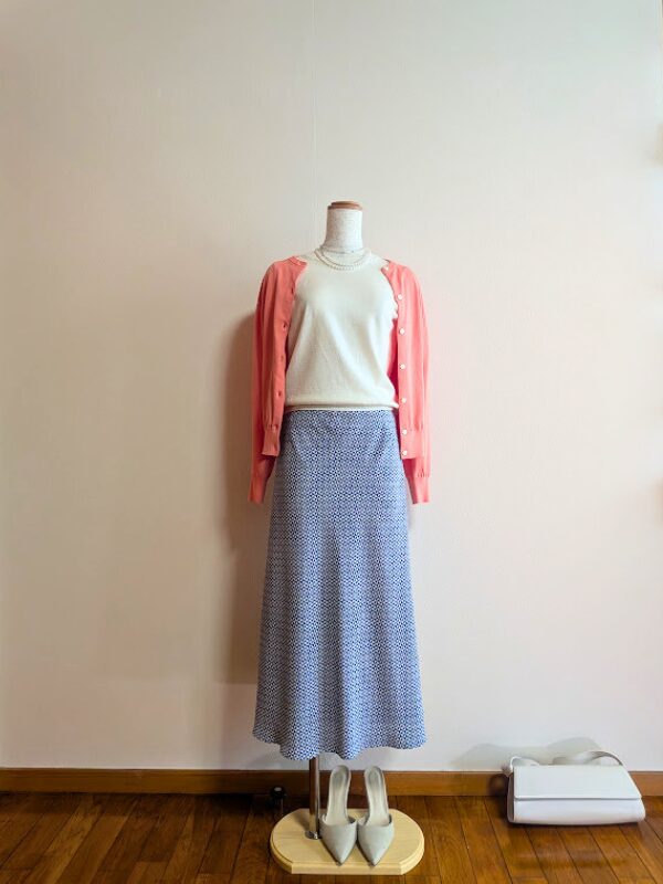40代・50代コーデ ⑥ライトベージュ半袖ニットにブルー柄マーメードスカートを合わせ、コーラルピンクカーディガンを重ねたトルソーコーデ