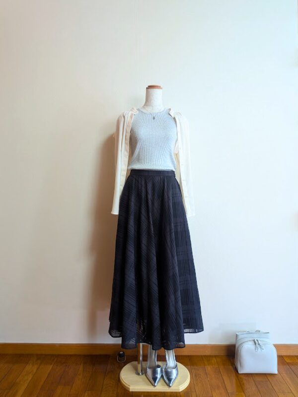 40代・50代コーデ ⑥ライトグレーノースリーブニットにブラックシアースカートを合わせ、ピンクベージュブラウスを掛けたトルソーコーデ