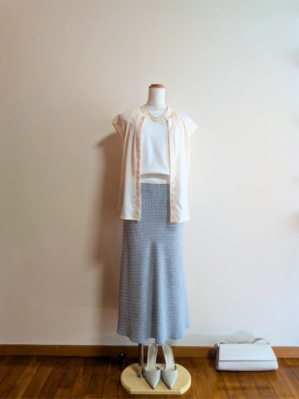 40代・50代コーデ ②ホワイトノースリーブニットにグリーン柄マーメードスカートを合わせ、ピンクベージュのノースリーブシャツを重ねたトルソーコーデ