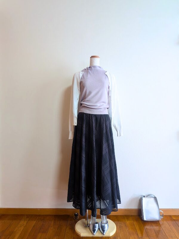 40代・50代コーデ ③ラベンダーノースリーブニットにブラックシアースカートを合わせ、ホワイトカーディガンを掛けたコーデ