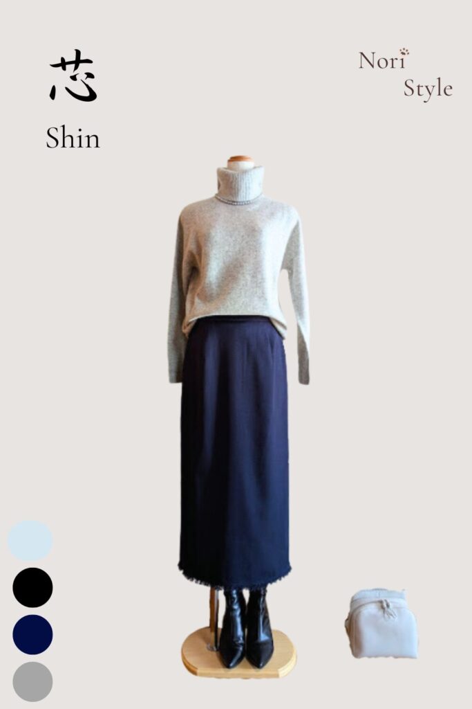 ライトグレーのカシミヤタートルニットにネイビーのタイトスカートを合わせた芯コーデ。足元はブラックのショートブーツで引き締め、そばにはライトミントのバッグを添えて、静けさの中にやわらかな彩りがひと筋通る上品なスタイル。
