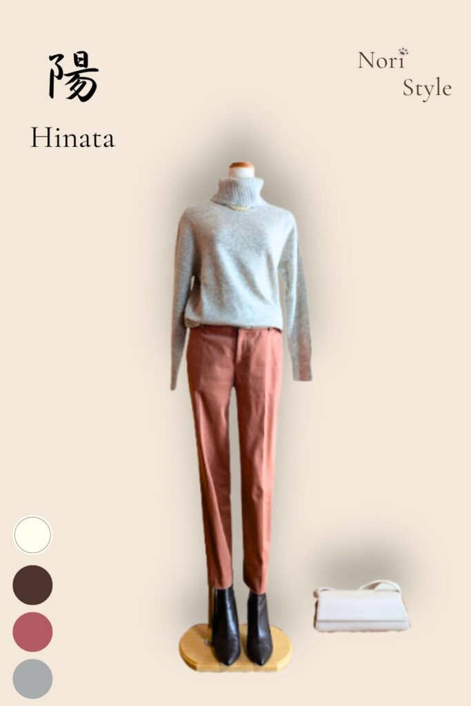 ライトグレーのカシミヤタートルニットに、くすみピンクのパンツを合わせた陽コーデ。足元はブラウンのショートブーツであたたかさを添え、そばにはオフホワイトのバッグを置いて、春の光がやわらかく差し込むような優しいスタイル。