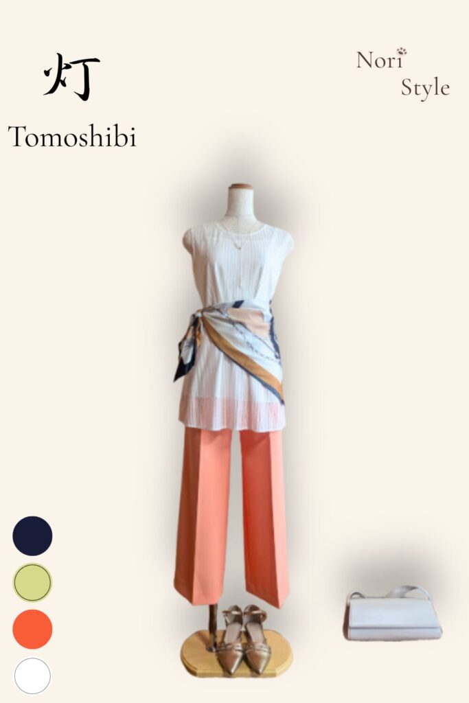 40代・50代大人の春夏きれいめコーデ【灯-Tomoshibi】。爽やかな白のノースリーブトップスに華やかなオレンジのセンタープレスワイドパンツ、腰元に巻いたドラマチックな柄スカーフ、上品な白のショルダーバッグを合わせた、華やかで品のある大人のトルソースタイリング