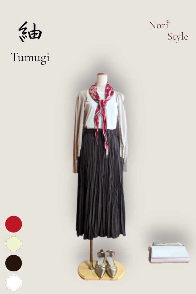 縦長の白を基調とした背景に、トルソーを配した「紬 — Tumugi」のコーディネートカード。落ち着いたダークブラウンのフレアスカートにホワイトのトップス、ライトゴールドのカーディガンを羽織り、マッキントッシュの赤スカーフを首元に添えたクラシカルな装いです。左上には端正な明朝体で「紬 — Tumugi」、右上には「Nori Style」のロゴ、左下にはカラー丸ドット(赤、白、ライトベージュ)が品よく配置されています。