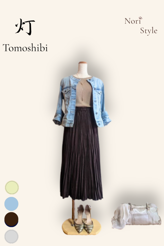 Nori Style「心のクローゼット」スタイリングボード。「灯 – Tomoshibi」の書とともに、ライトブルーのGジャン、ライトブラウンのニット、ダークブラウンのプリーツロングスカート、ライトゴールドのパンプスのトルソーコーディネートを掲載。右下にはライトベージュのストールとライトゴールドのバッグを配置。左下には構成色を表すイエロー、ブルー、ブラウン、グレーの4色のカラーサークル。